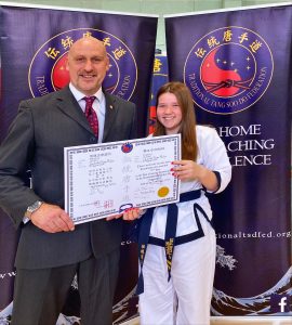 Isabelle Suter being presented with a Korean Karate certificate.