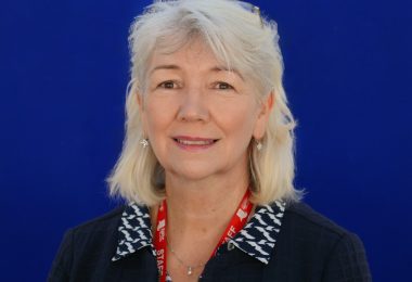 Portrait of Lisa Jenkins on blue background.